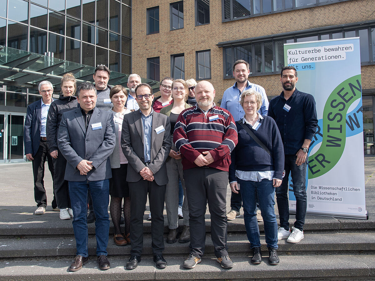 Group photo of the team In terris Gryphi in front of the Greifswald University Library